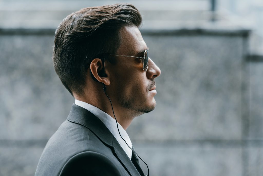 profile of handsome bodyguard with sunglasses and security earpiece