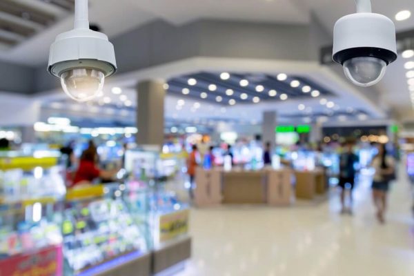 closeup-cctv-security-camera-on-blurred-inside-shopping-mall-background